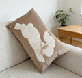 Decorative pillow with angel wings on a beige sofa in a living room setting.