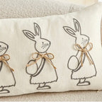 Decorative pillow with embroidered bunnies on a neutral background