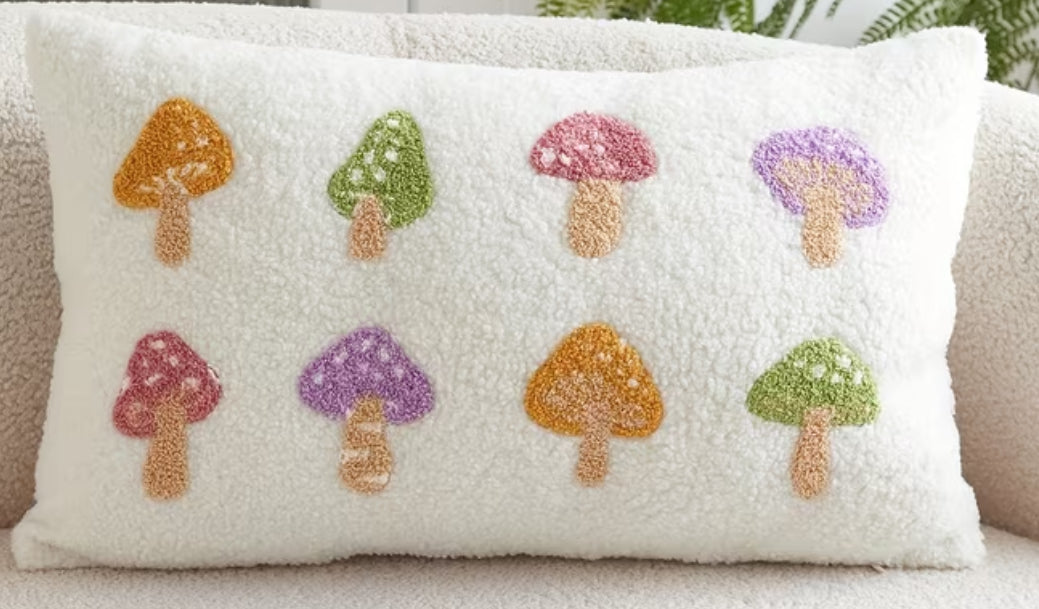 Decorative pillow with embroidered mushrooms on a soft surface