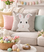 Decorative pillow with a bunny face on a couch with Easter decorations.