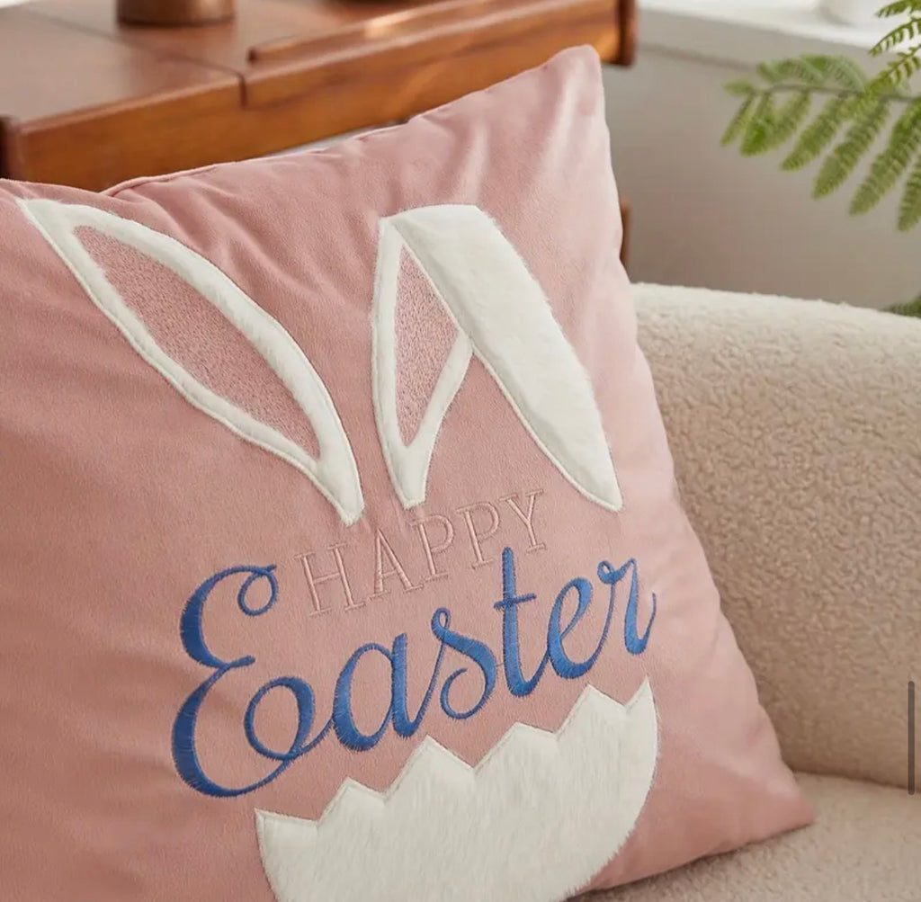Pink pillow with 'Happy Easter' text and bunny ears on a couch.