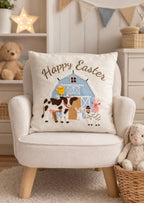 Decorative pillow with 'Happy Easter' and farm animal design on a chair in a cozy room.