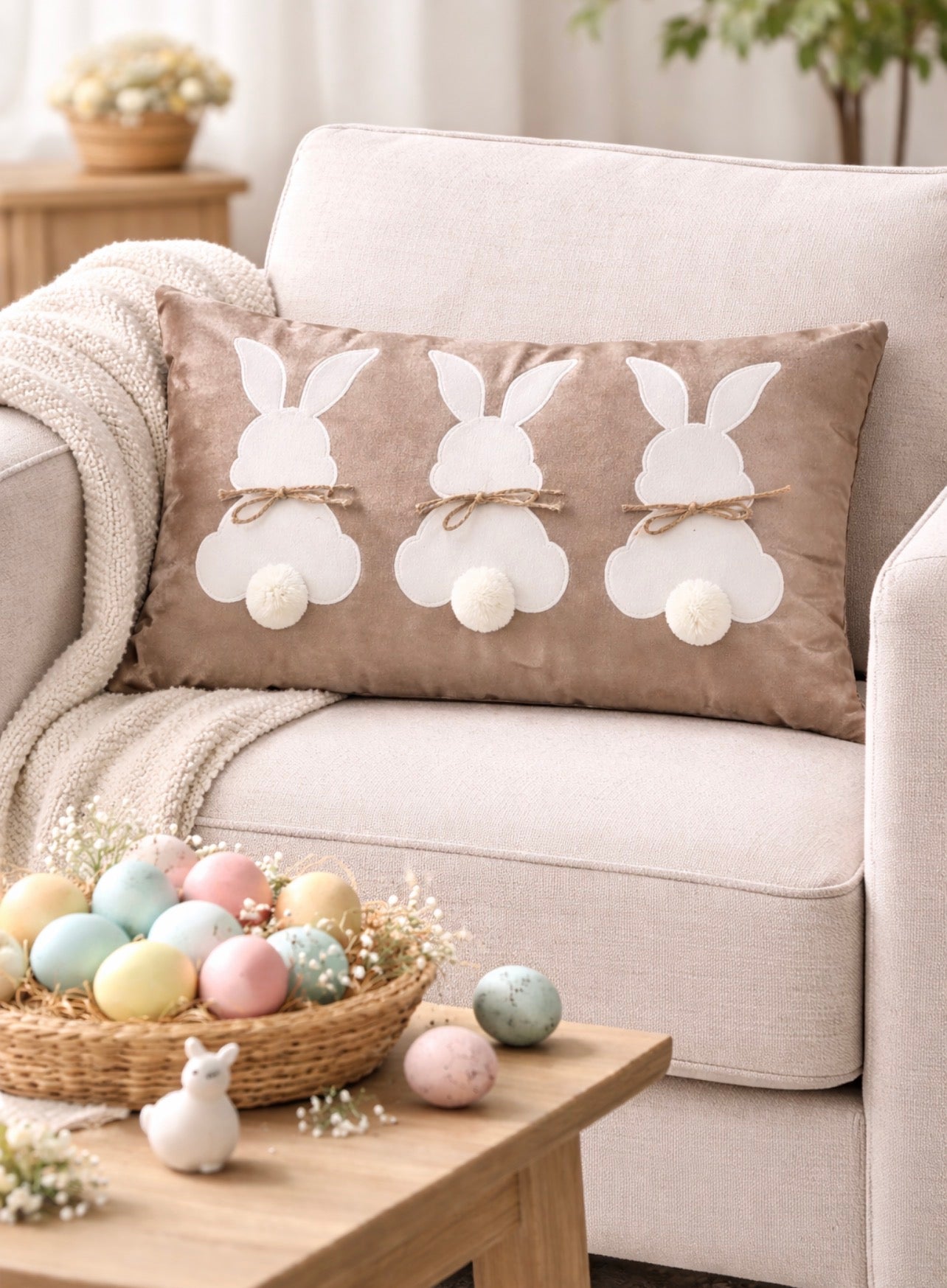 Decorative pillow with bunny designs on a couch, surrounded by Easter eggs and decor.