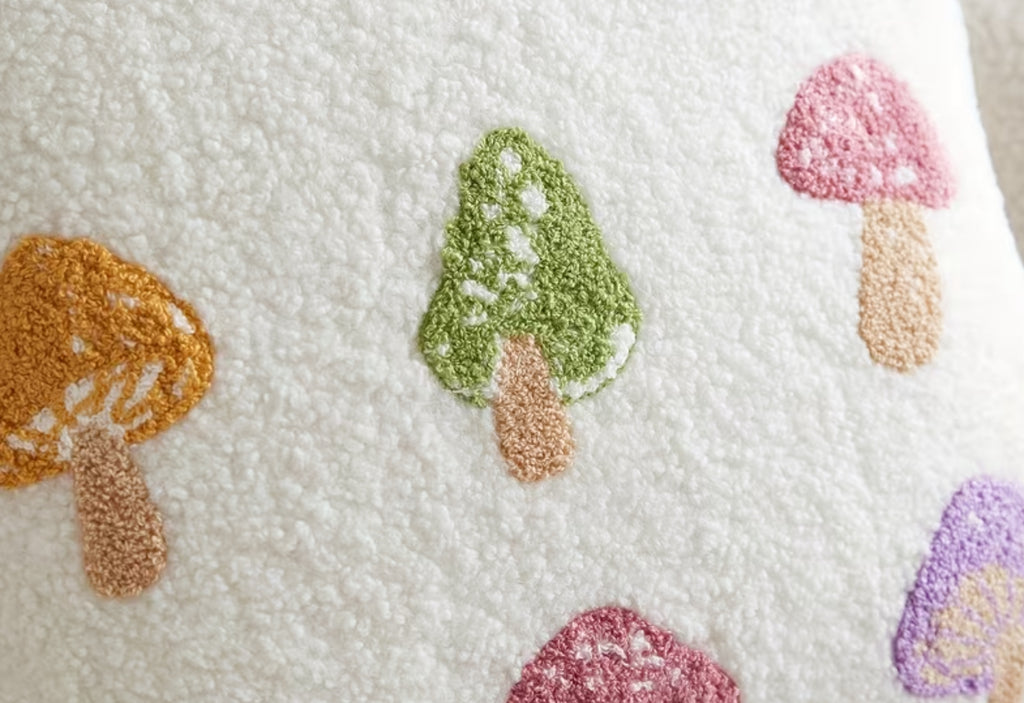 Decorative pillow with embroidered mushrooms on a textured fabric background