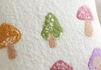 Decorative pillow with embroidered mushrooms on a textured fabric background