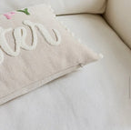 Decorative pillow with floral embroidery on a beige sofa