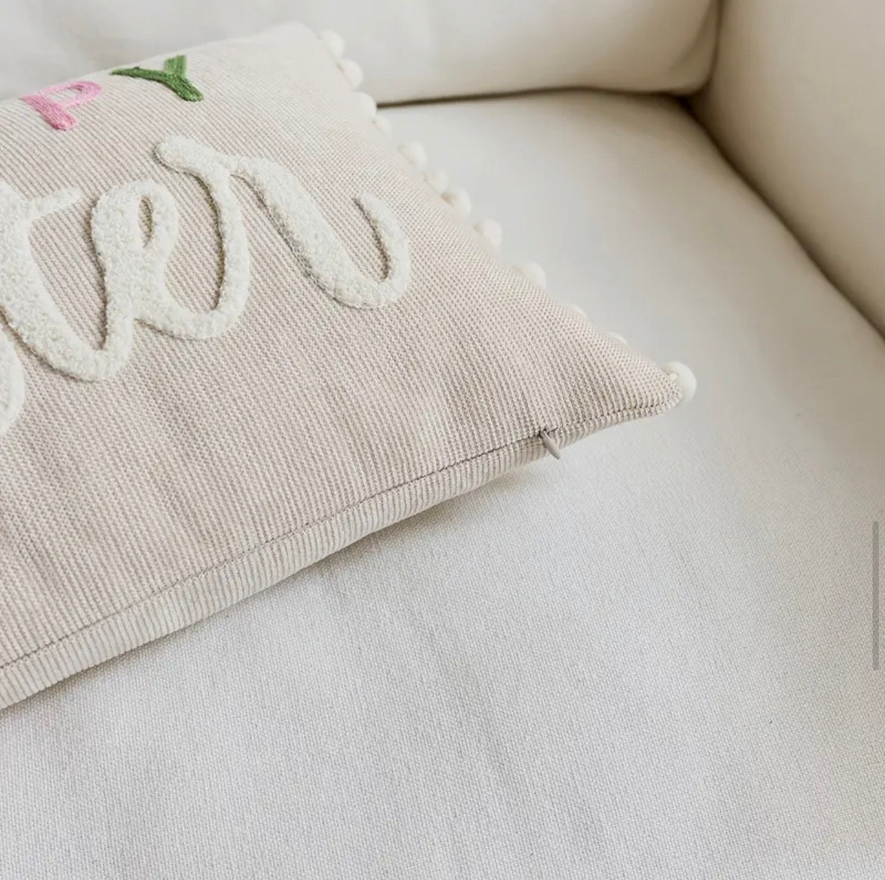 Decorative pillow with floral embroidery on a beige sofa