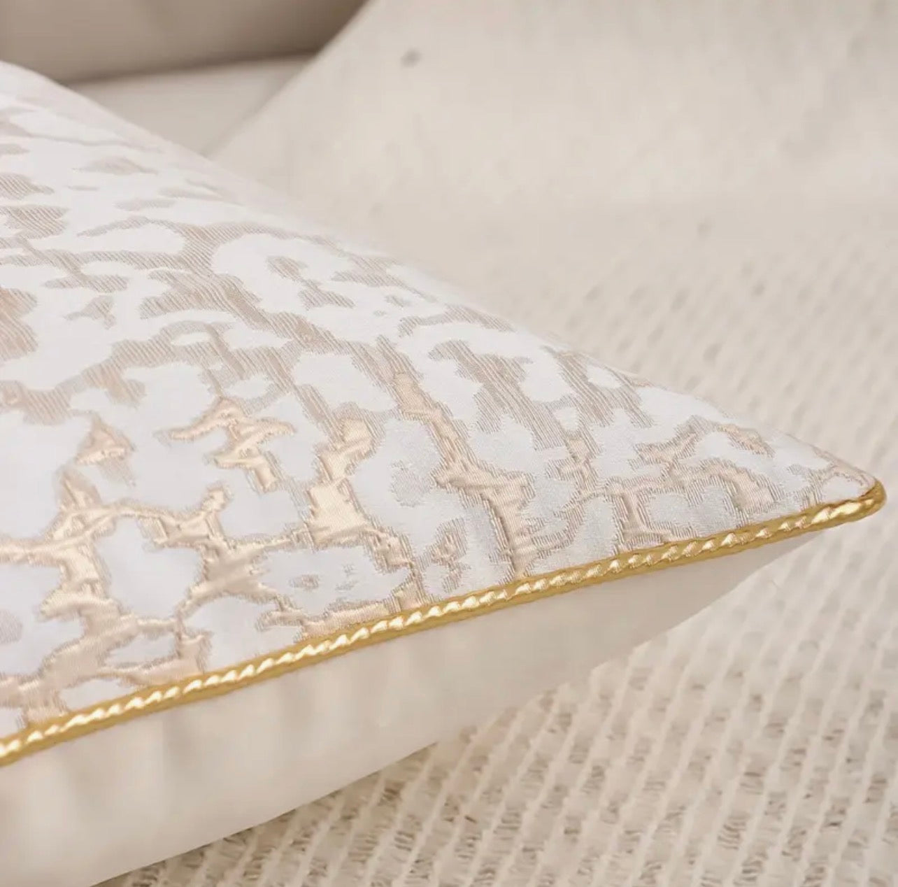 Decorative pillow with intricate lace pattern on a neutral background