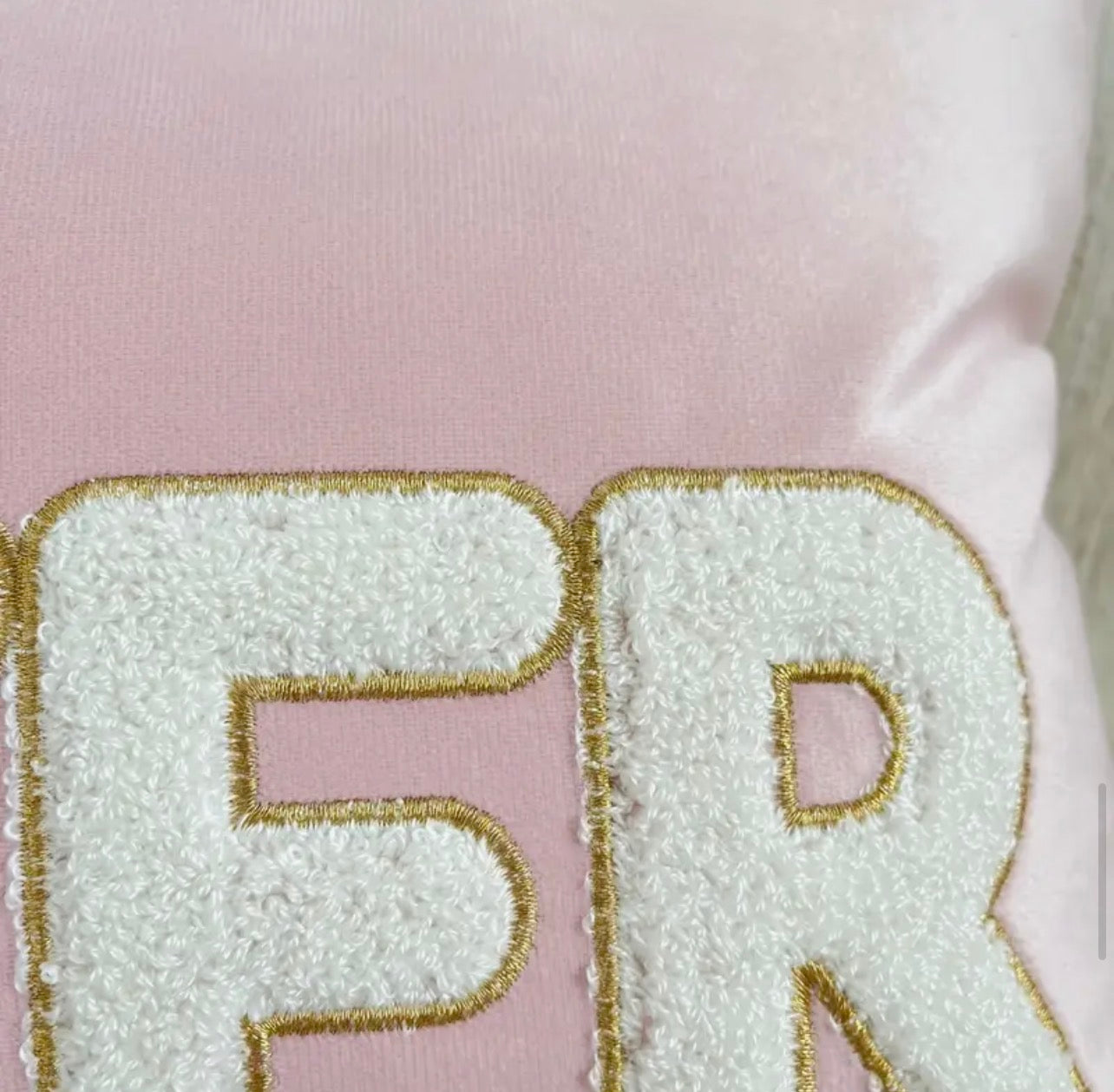 Close-up of textured letters 'FR' on a pink background