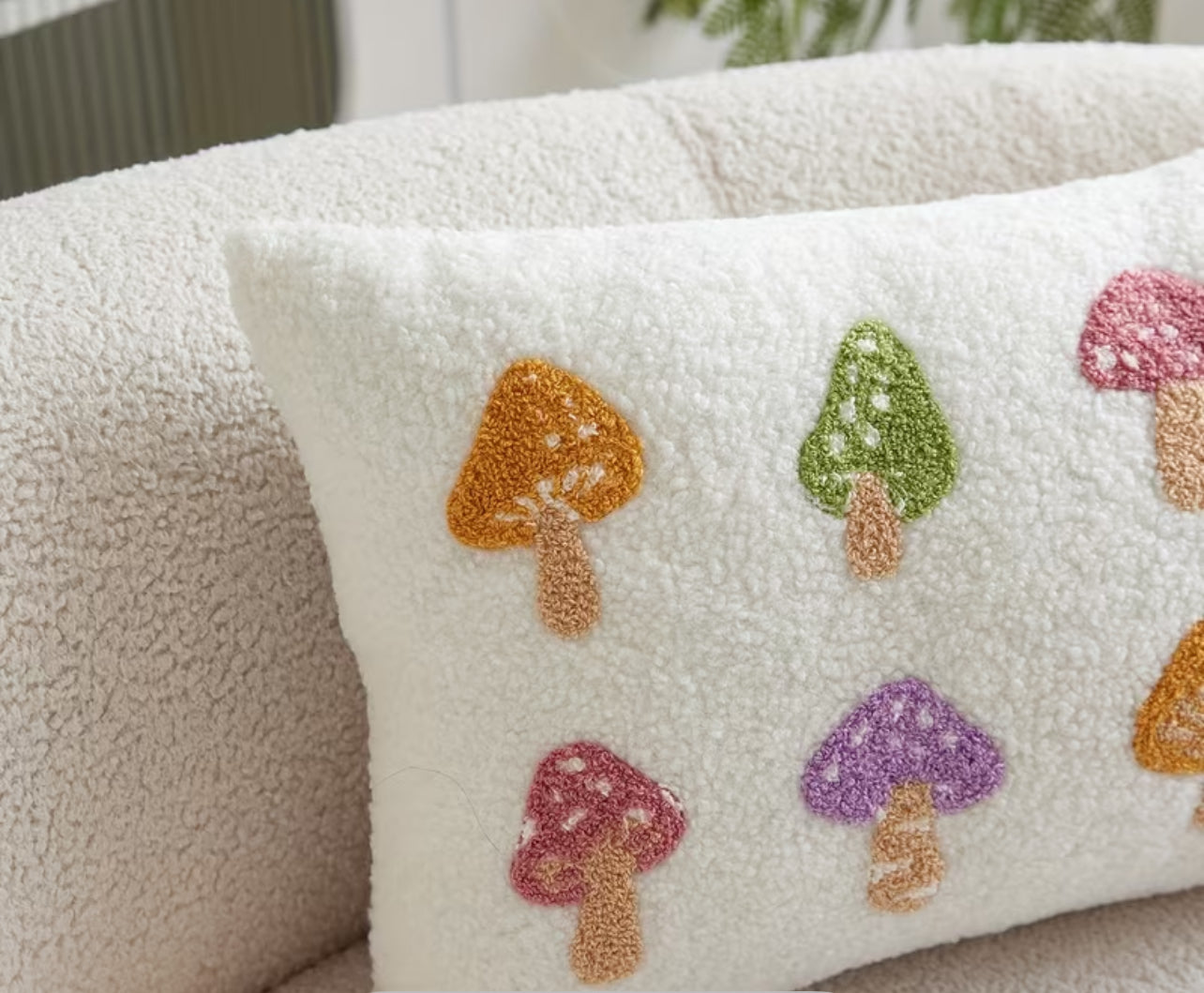 Decorative pillow with colorful mushroom patterns on a textured surface.