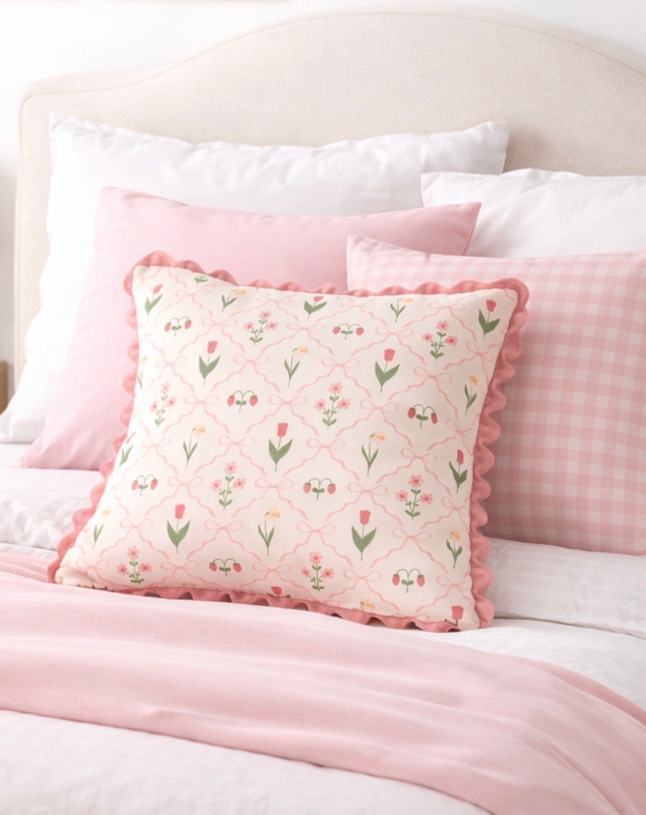 Floral patterned pillow on a bed with pink bedding