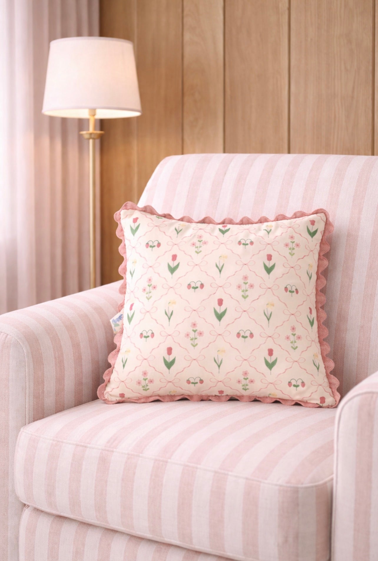 Decorative pillow with floral pattern on a striped armchair in a room with wooden paneling.