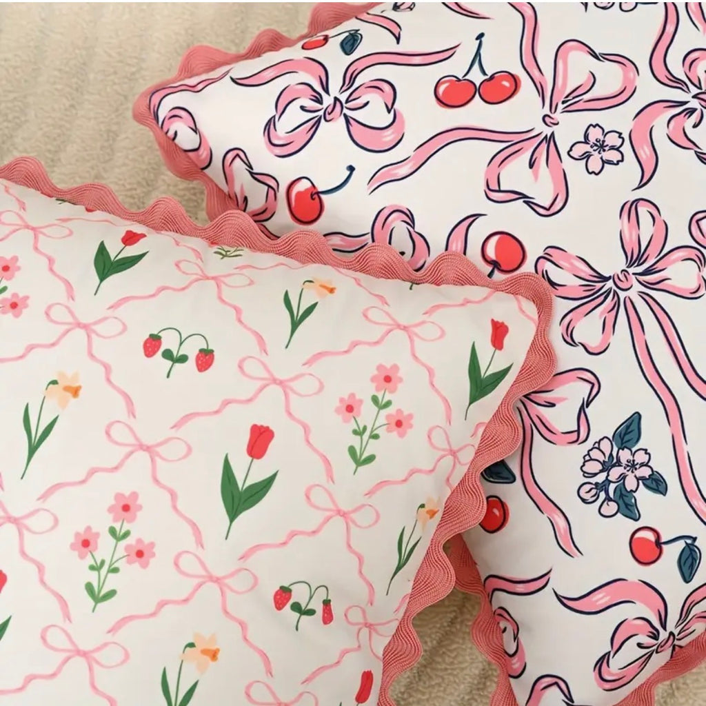 Two decorative pillows with floral and bow pattern on a beige surface