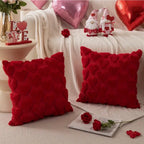 Decorative pillows with heart patterns on a couch with Valentine's Day decor.