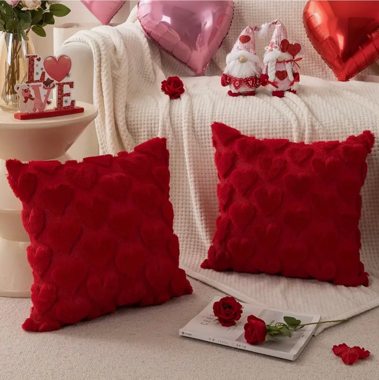 Decorative pillows with heart patterns on a couch with Valentine's Day decor.