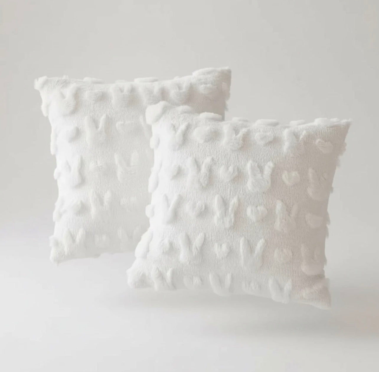 Two textured white pillows on a light gray background