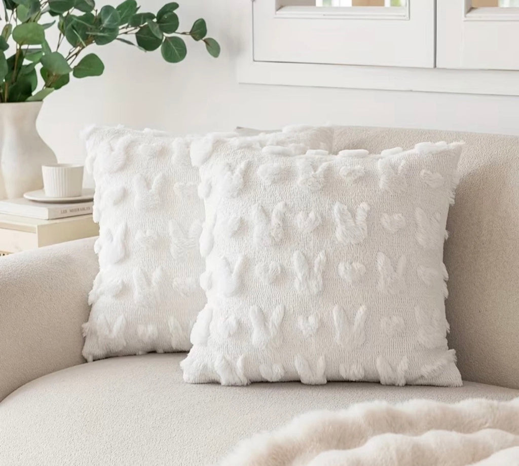 Textured white pillow on a beige sofa with a neutral background
