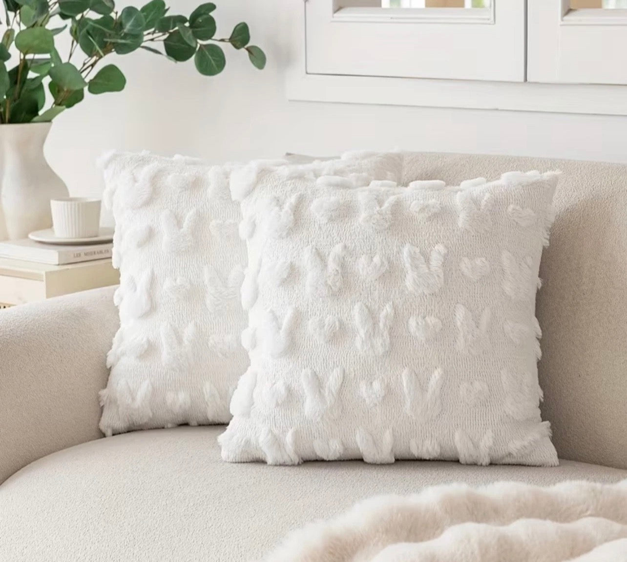 Textured white pillow on a beige sofa with a neutral background