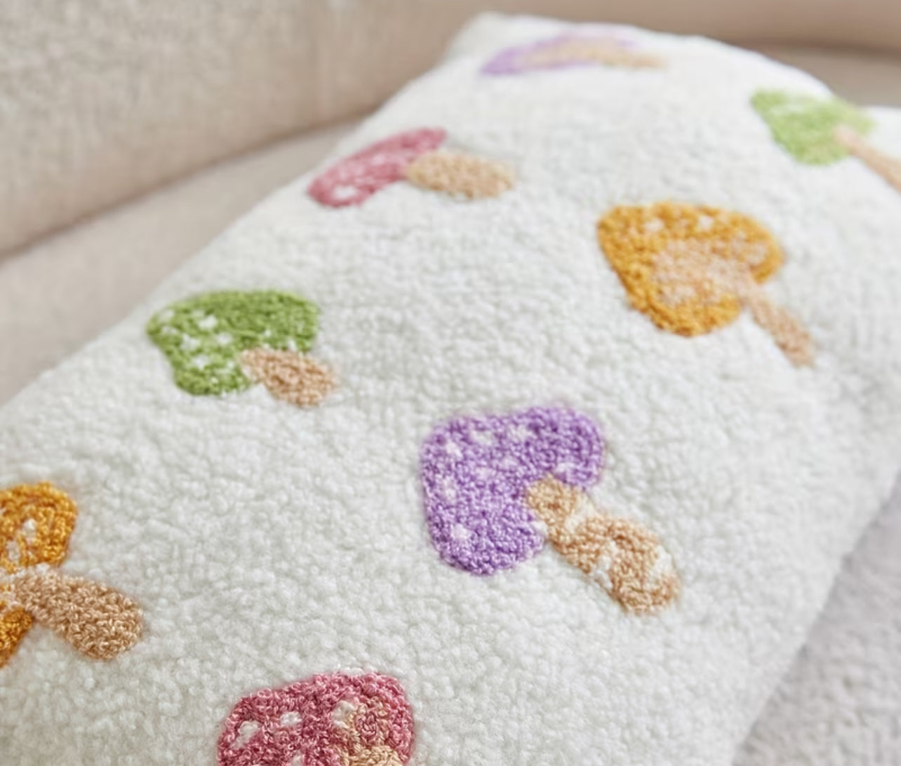 White towel with colorful mushroom patterns on a neutral background