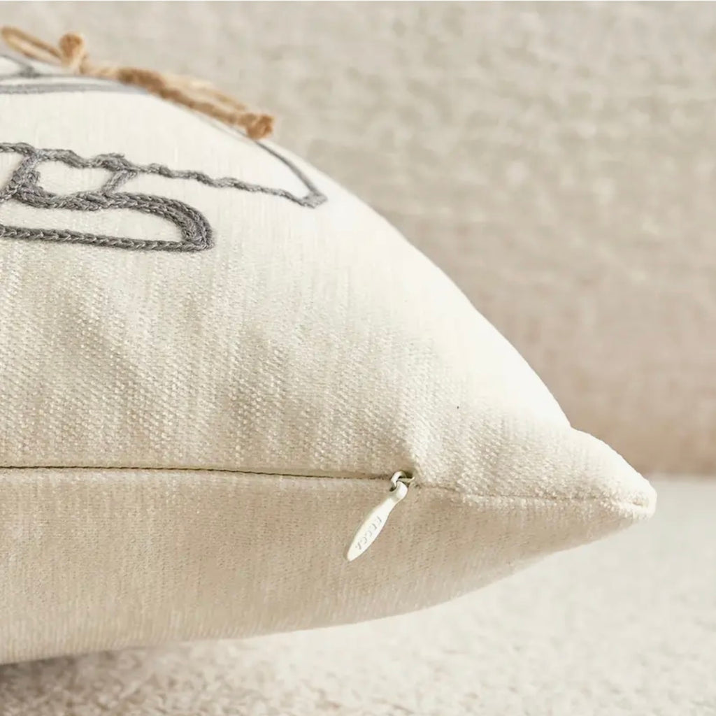 Close-up of a textured pillow with decorative stitching on a neutral background