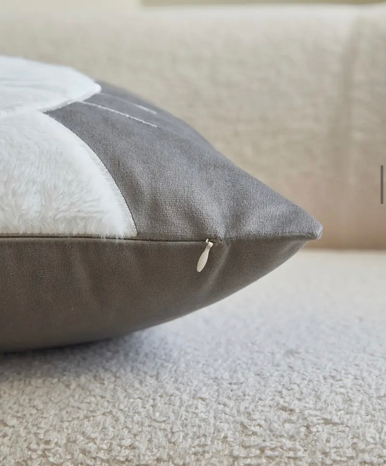 Showing a zipper on a grey and cream cushion 