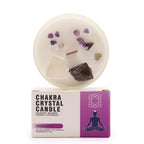 Chakra crystal candle with decorative stones on top of its packaging box.