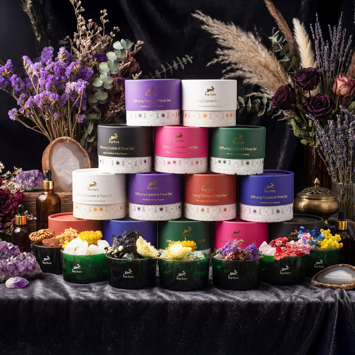Assorted scented candles in colorful tins on a dark surface with decorative flowers and elements.