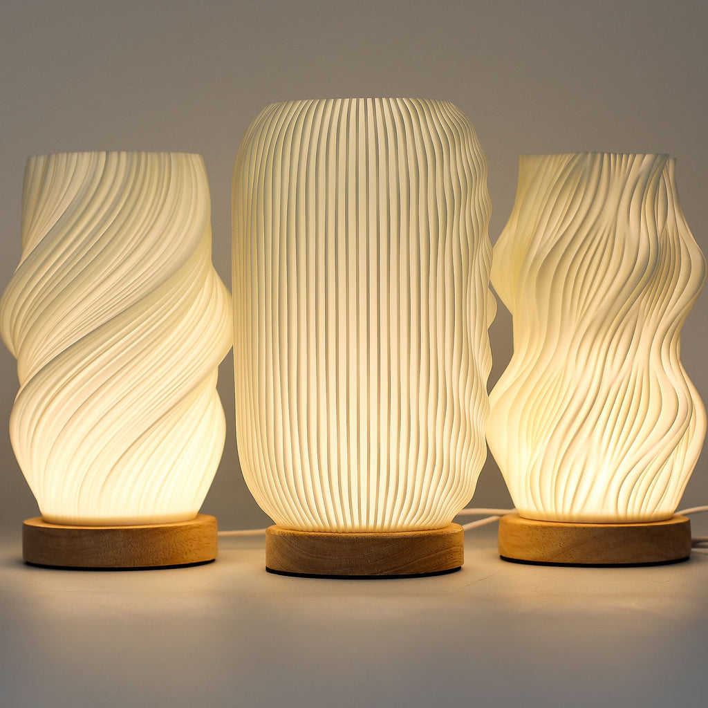 Three textured table lamps with wooden bases on a neutral background