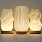 Three textured table lamps with wooden bases on a neutral background