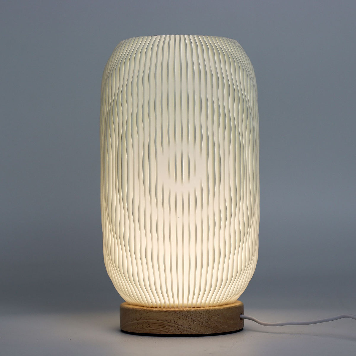 Textured table lamp with wooden base on a gray background