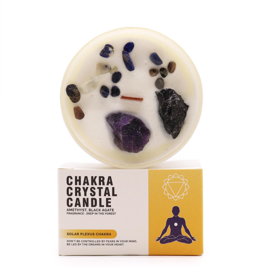 Chakra crystal candle with visible stones on a white background