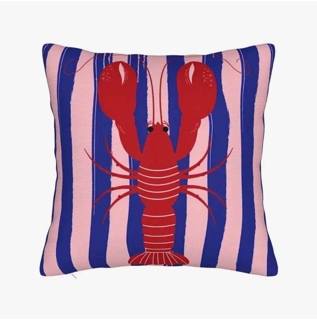 Pillow with a red lobster design on a blue and pink striped background