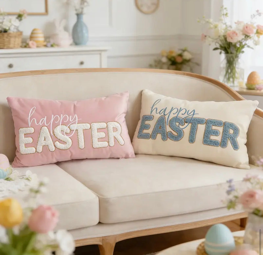 Two 'Happy Easter' pillows on a sofa with decorative eggs and flowers in the background.
