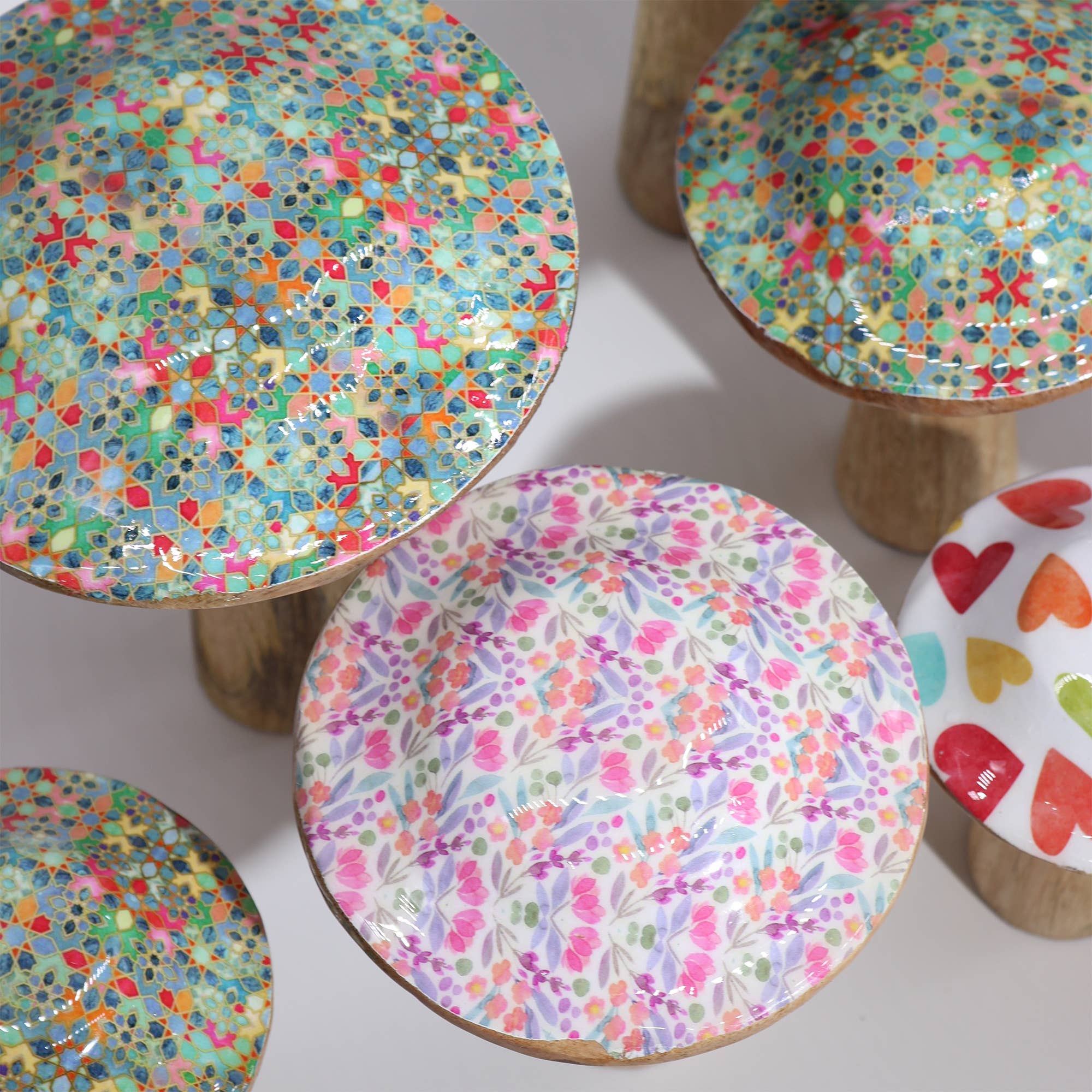 Colorful patterned stools with wooden legs on a light background