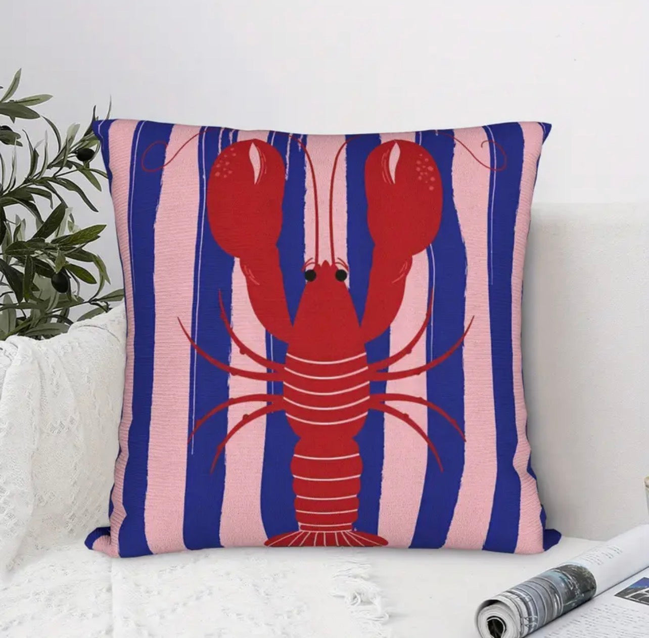 Decorative pillow with a red lobster on a blue and pink striped background